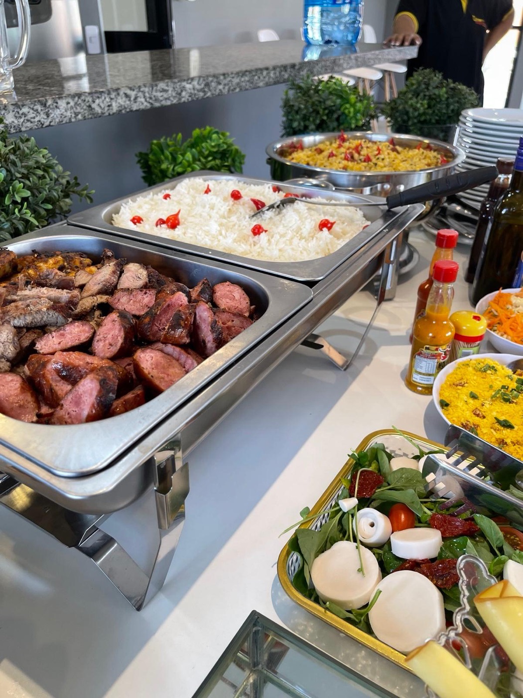 Buffet montado com carnes, arroz, farofa e salada de palmito
