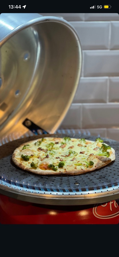 Pizza saindo do forno a lenha