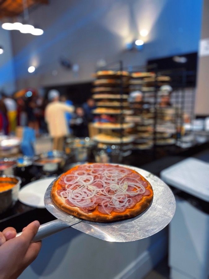 Pizza sendo servida aos convidados durante o rodízio